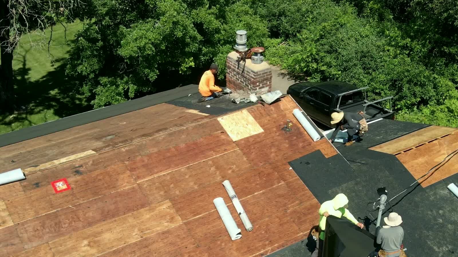 Smart Construction crew working across an exterior roofing project with materials staged on the roof.